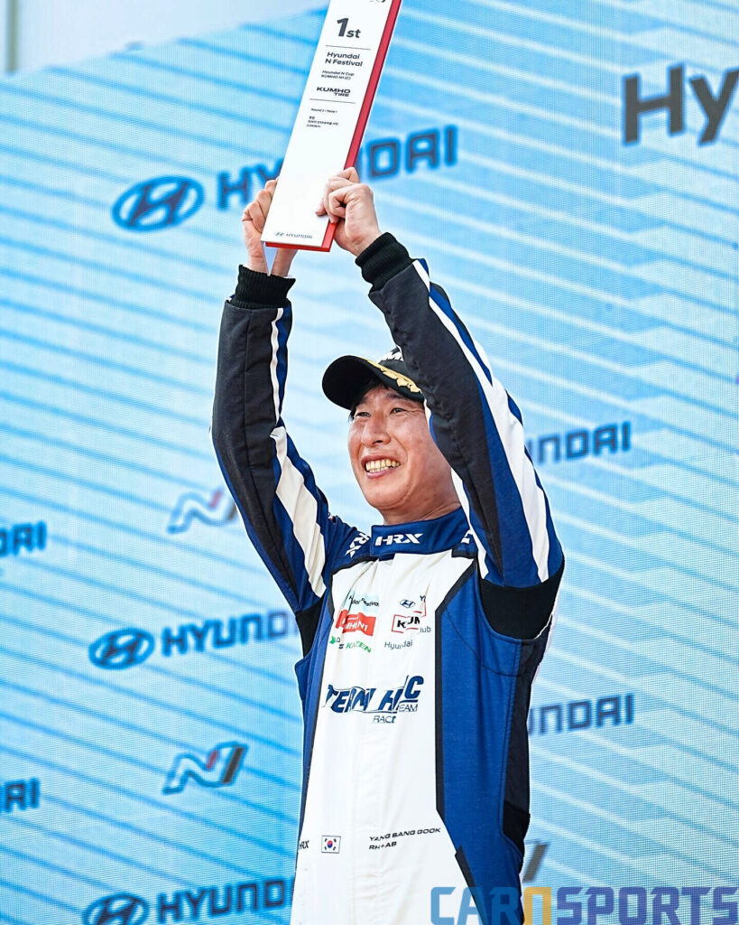 포디움에서 양상국이 1위 트로피를 들어올리고 있다.